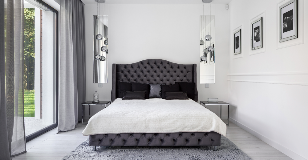 <strong>Styl glamour</strong> ma na celu intrygowanie, onieśmielanie i olśniewanie, daleki jest od umiaru, uwielbia obszerne pikowane sofy, rozłożyste fotele, barokowe meble i skórzane krzesła. Styl glamour uwielbia błyszczeć i to w dosłownym znaczeniu. Dlatego w mieszkaniach urządzonych w tym stylu natkniemy się na wykończone na wysoki połysk podłogi, lakierowane meble, kryształowe żyrandole, odbijające światło złote sztućce i zastawy, duże lustra w ozdobnych ramach i błyszczące tkaniny. Kolorystyka stylu glamour jest stonowana, pozwalając efektywnym meblom i innym elementom wyposażenia grać pierwsze skrzypce. Ściany w stylu glamour często maluje się na delikatne beże, szarości, biel i czerń, a także fiolety. Styl glamour w szczególny sposób upodobał sobie kolor fioletowy, zwłaszcza w jego ciemniejszym odcieniu. We wnętrzach w stylu glamour nie może również zabraknąć klasycznych sztukaterii, które przywodzą na myśl wystrój pałacowy i nadają wnętrzom szyku i luksusowego charakteru. zdjęcie